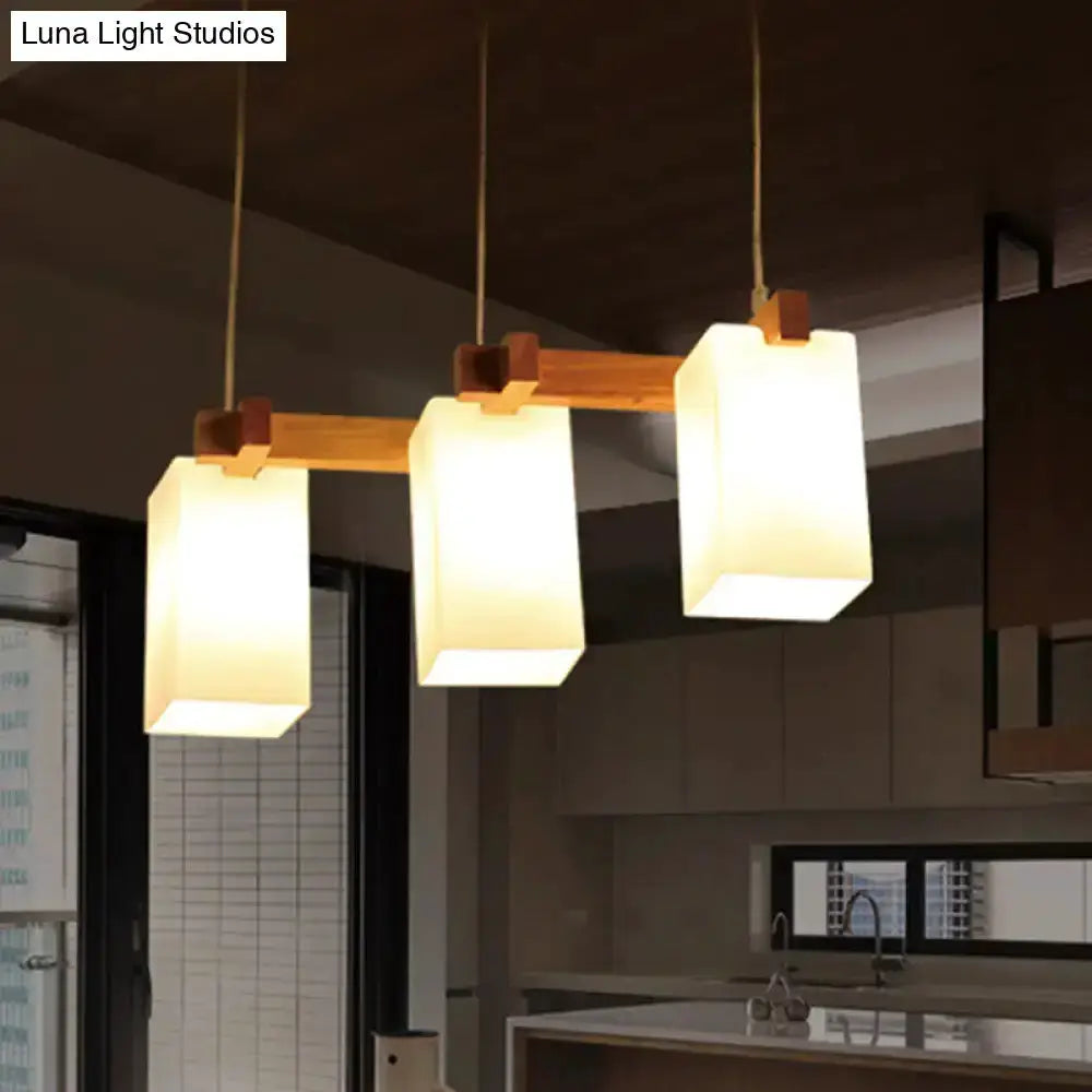 Wood and white glass cluster pendant light with three shades on a wood bar Decorbites on Tampa Home & Garden Store