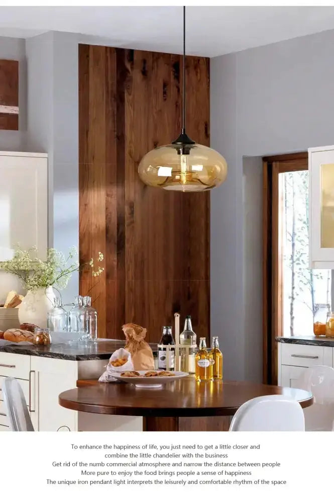 Decorbites amber smoky gray glass LED pendant light over round wooden dining table on Tampa Home & Garden Store