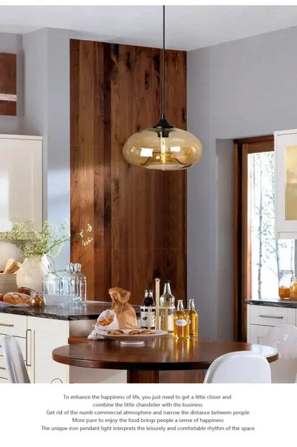 Decorbites amber smoky gray glass LED pendant light over round wooden dining table on Tampa Home & Garden Store