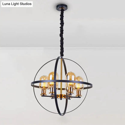 Industrial amber glass pendant chandelier with brass accents inside a black spherical frame on Tampa Home & Garden Store