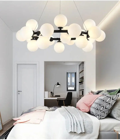 Black Gold Glass Ball Chandelier by Decorbites with white globe bulbs over a modern bedroom on Tampa Home & Garden Store
