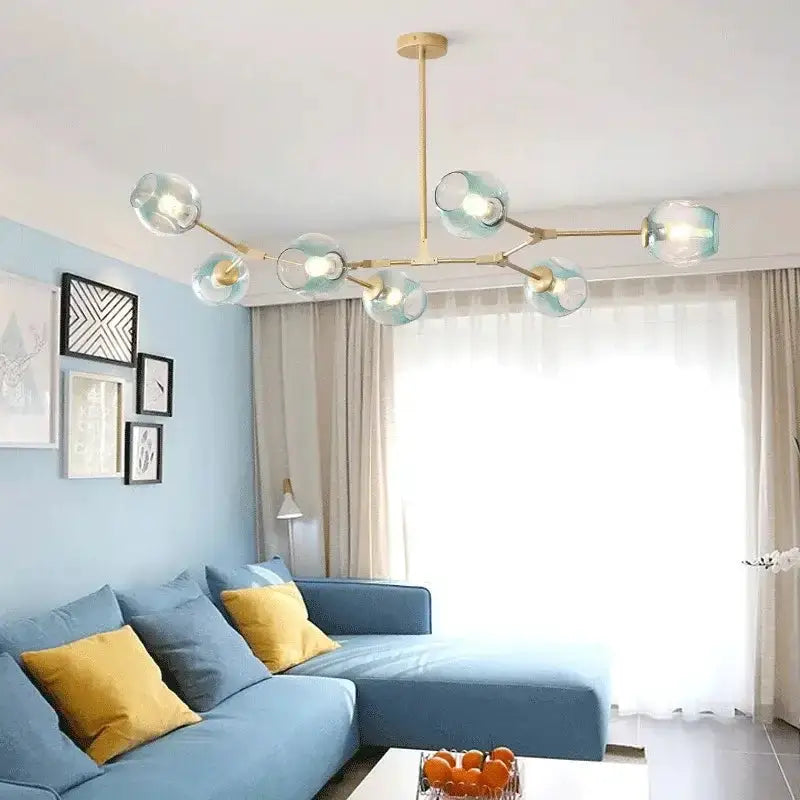 Decorbites teal glass bubble chandelier with eight globes over a blue sectional living room on Tampa Home & Garden Store