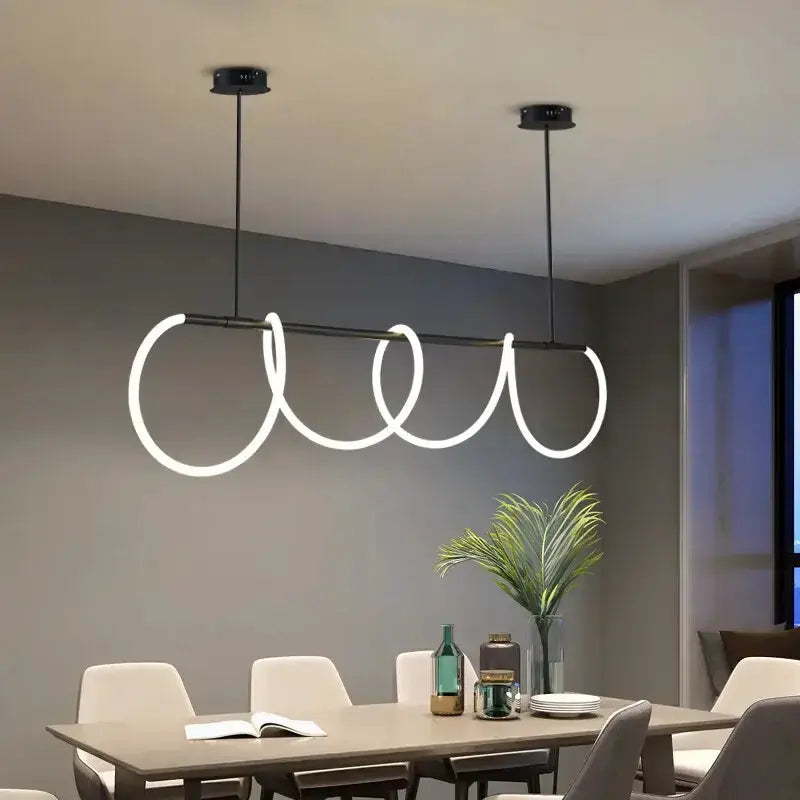 Modern gold curved pendant LED chandelier with looping rings over dining table by Decorbites on Tampa Home & Garden Store