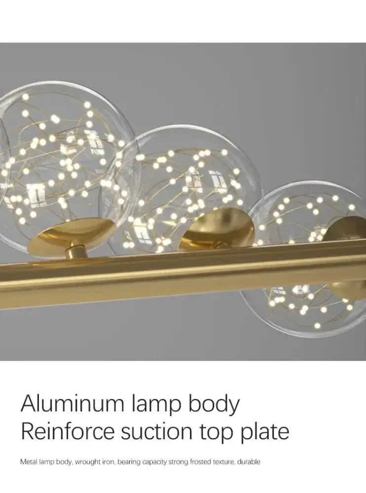 Modern gold long ceiling chandelier with clear glass globe pendants and warm LED lights on Tampa Home & Garden Store