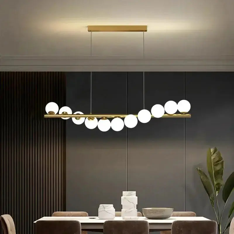Modern gold ceiling chandelier with glass globe pendants and gold bar by Decorbites dining table on Tampa Home & Garden Store