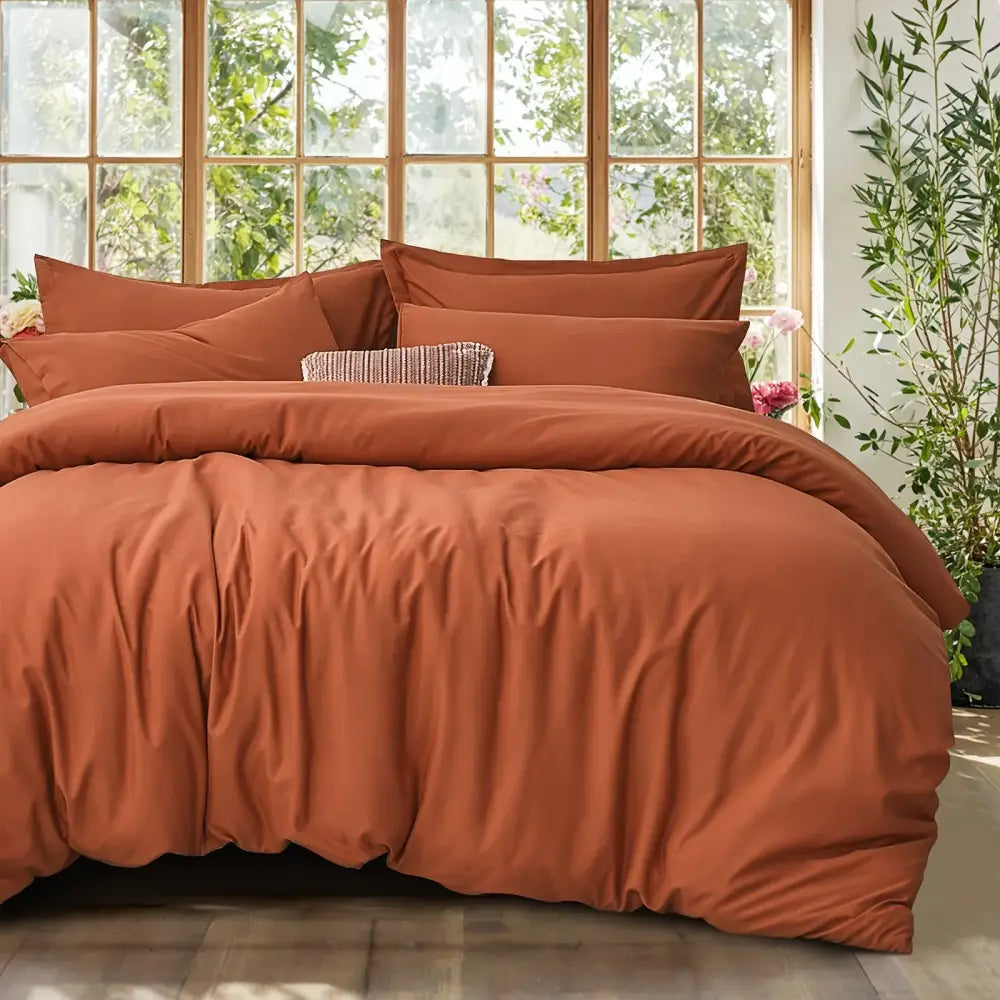 Black satin duvet set with matching pillow shams by Decorbites on rust-orange bed on Tampa Home & Garden Store