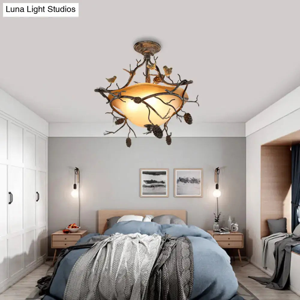 Bronze bird-branch ceiling light with amber glass shade and perched birds on branches on Tampa Home & Garden Store