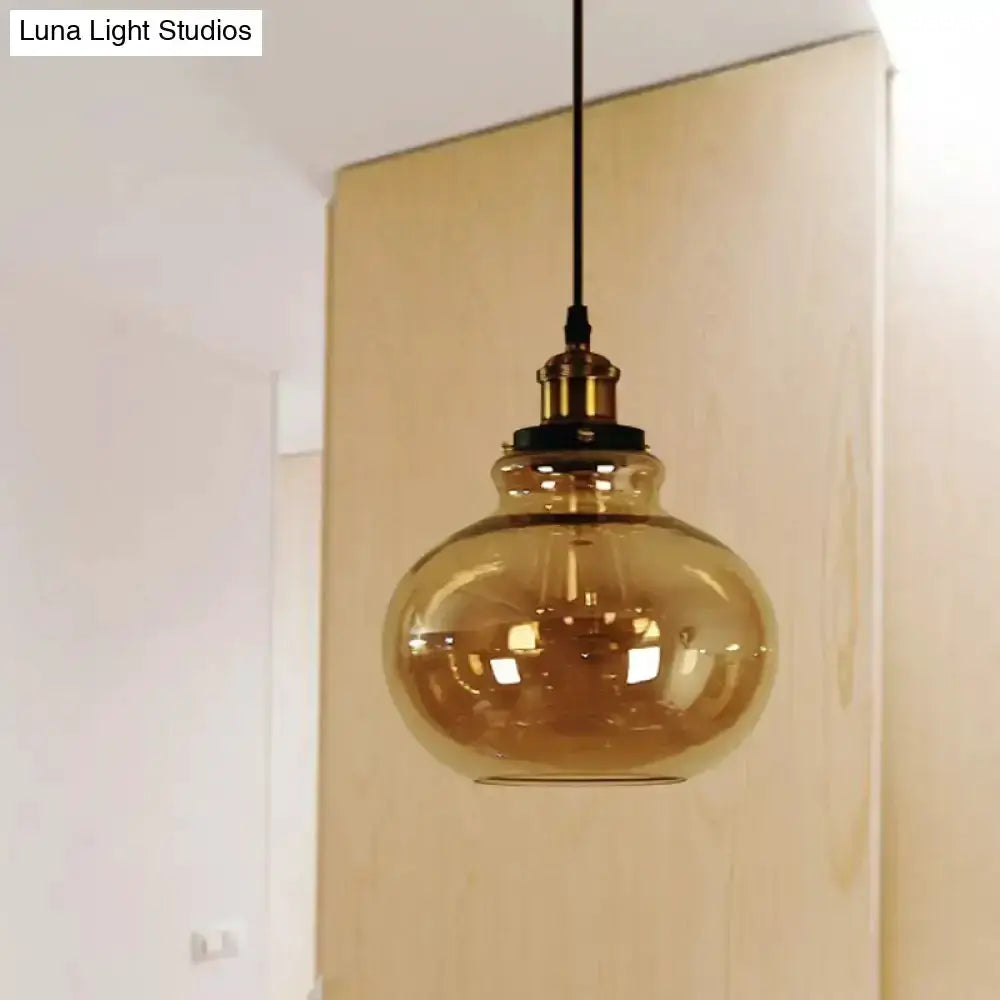 Farmhouse brass pendant light with amber glass globe and black cord on Tampa Home & Garden Store