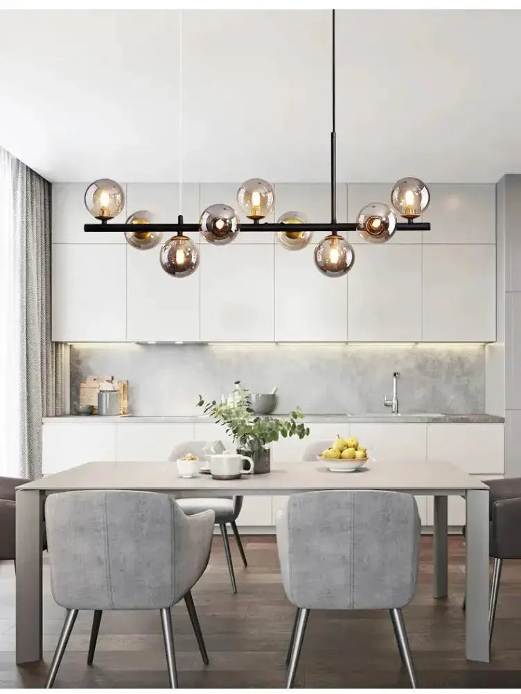 Modern gold glass ball chandelier with a black bar and multiple globes above a dining table on Tampa Home & Garden Store