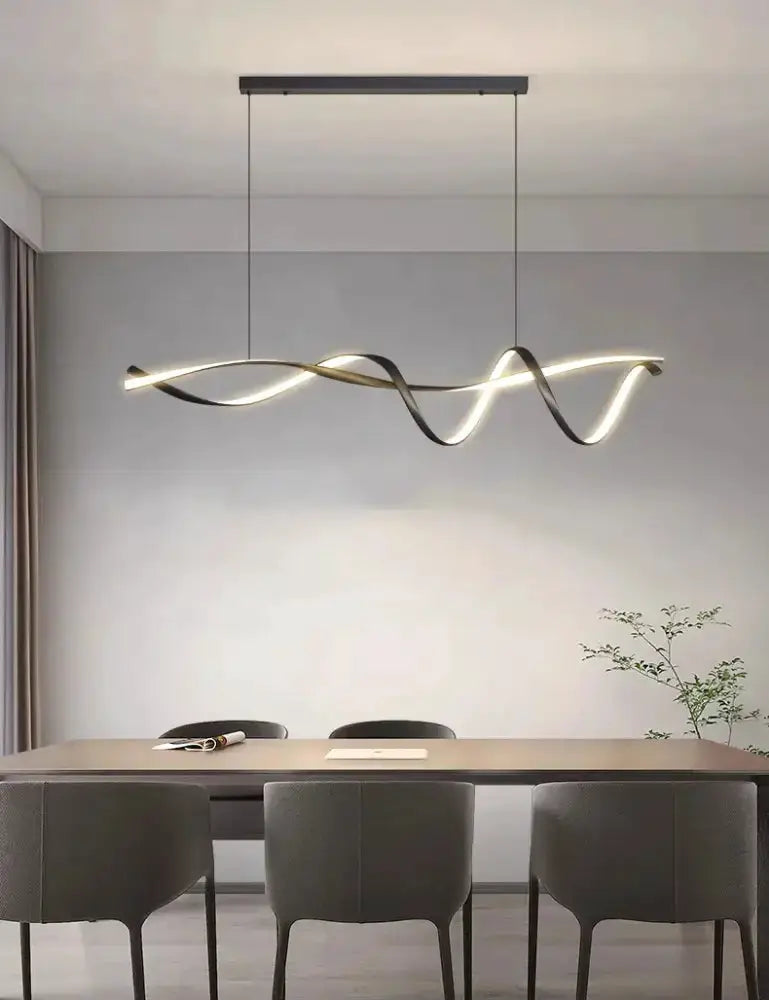 Chandelier modern black and gold wave LED glass pendant light over dining table with gray chairs on Tampa Home & Garden Store