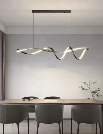 Chandelier modern black and gold wave LED glass pendant light over dining table with gray chairs on Tampa Home & Garden Store