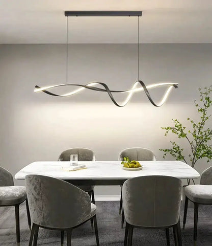Modern black and gold wave LED glass pendant light above a marble dining table with grey chairs on Tampa Home & Garden Store