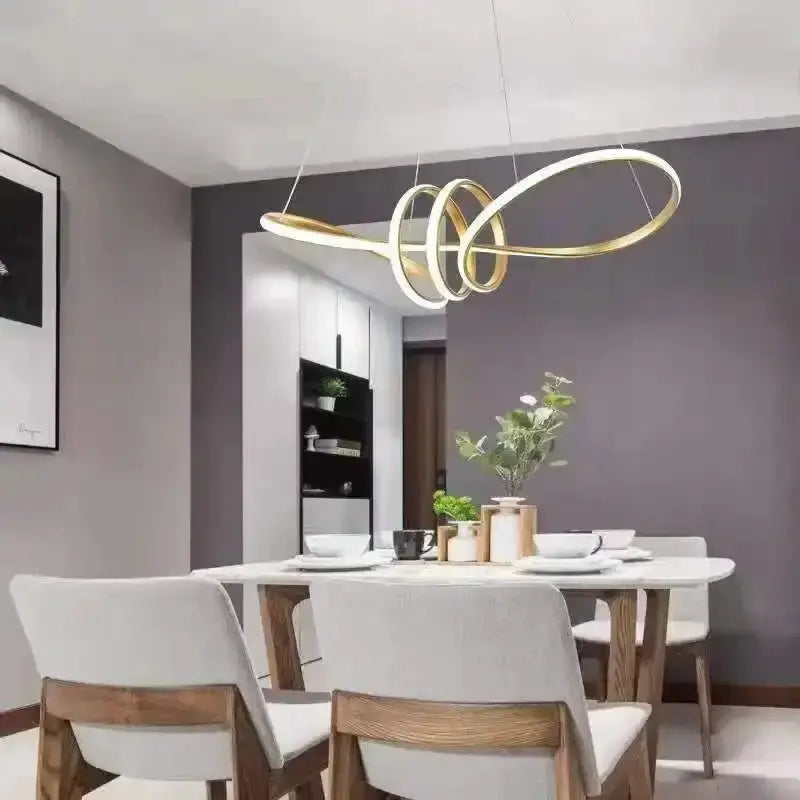 Modern black and gold wave LED glass pendant chandelier by Decorbites over a white dining table on Tampa Home & Garden Store