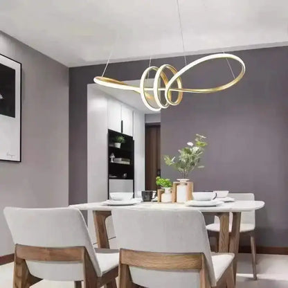 Modern black and gold wave LED glass pendant chandelier by Decorbites over a white dining table on Tampa Home & Garden Store