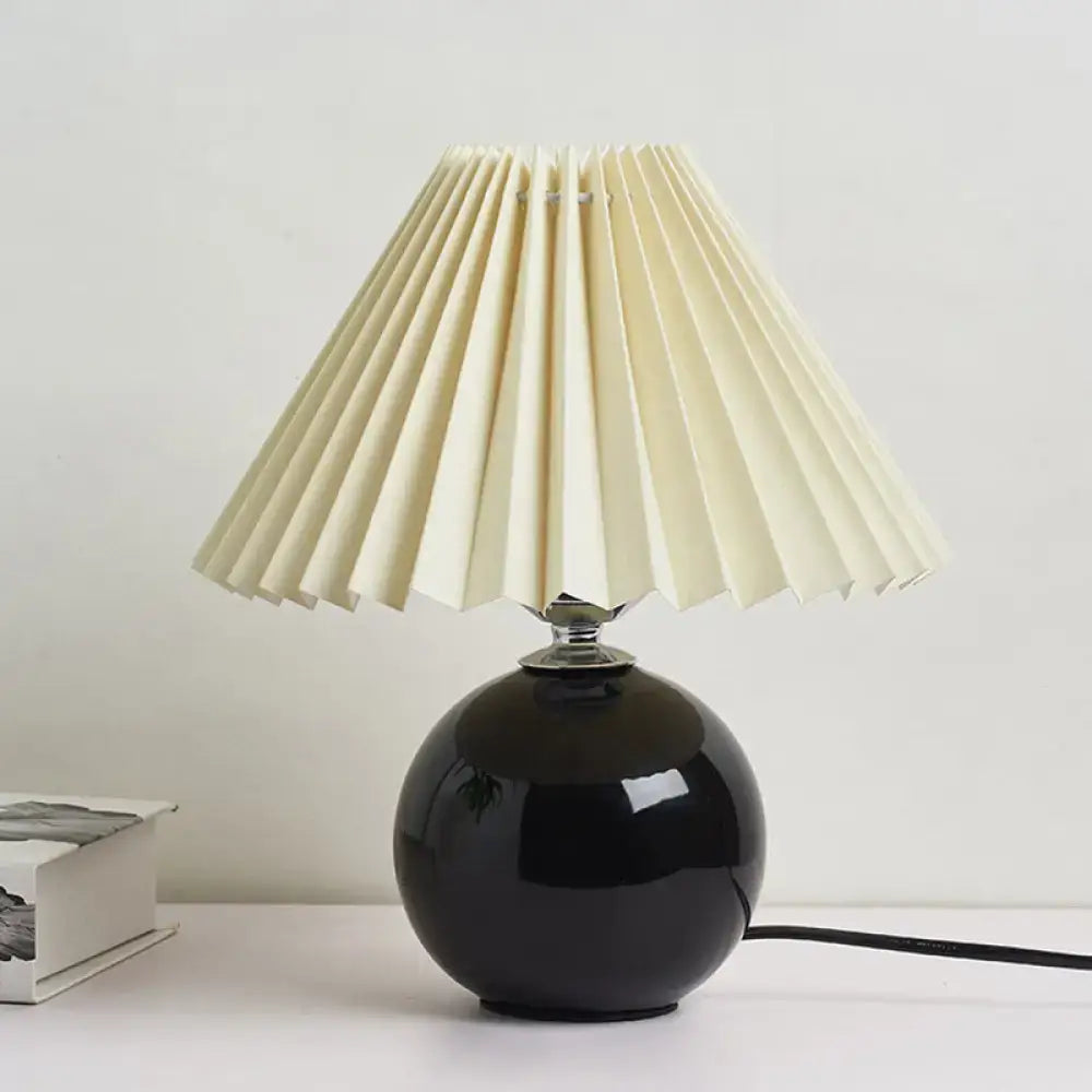 Black ceramic bedside lamp by Decorbites with round base and white pleated shade on Tampa Home & Garden Store