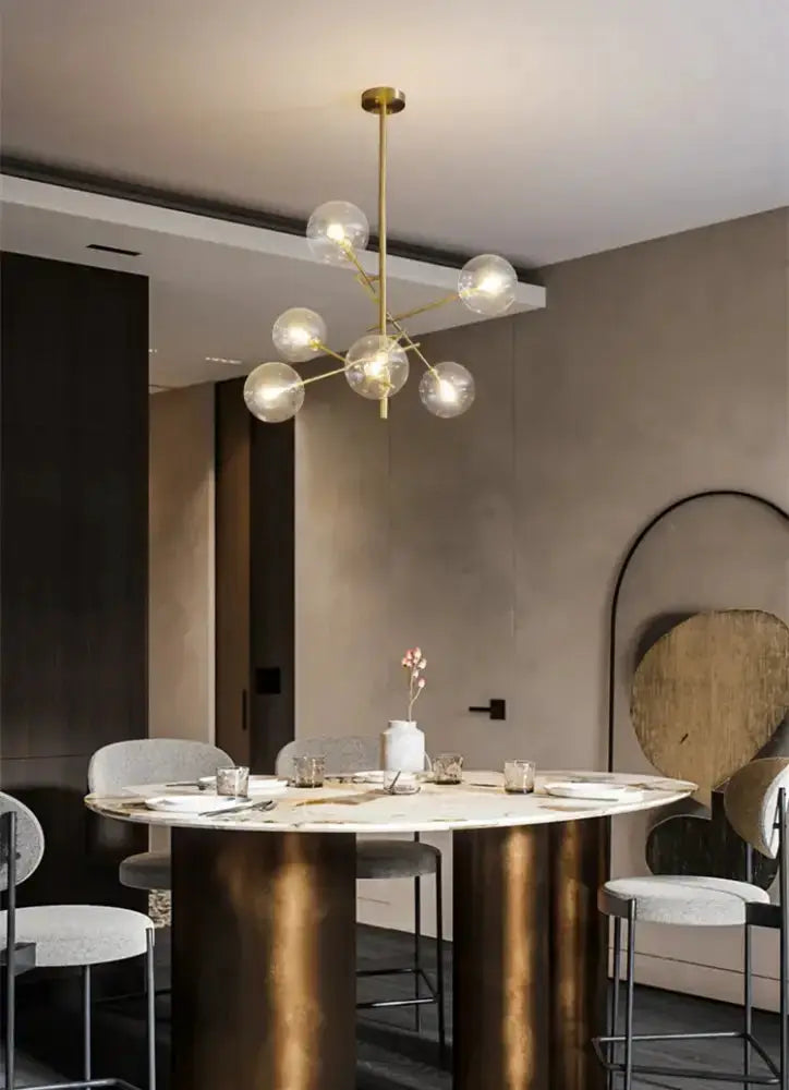 Chandelier Decorbites gold glass bubble starburst globe bulbs over marble dining table on Tampa Home & Garden Store