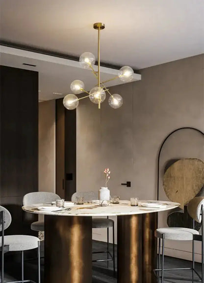 Chandelier Decorbites gold glass bubble starburst globe bulbs over marble dining table on Tampa Home & Garden Store