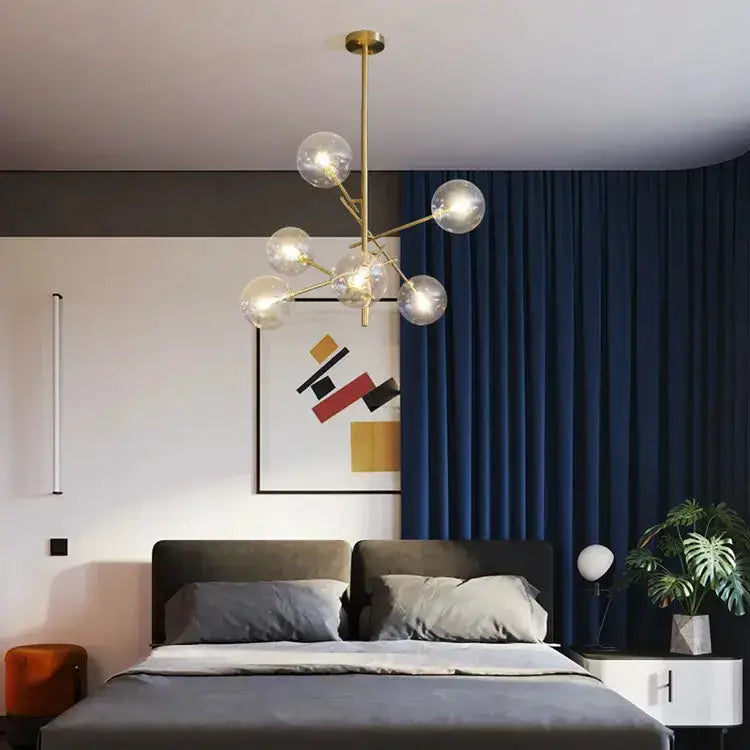 Chandelier Decorbites gold glass bubble starburst over a gray bed in a room with navy curtains on Tampa Home & Garden Store