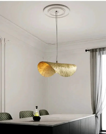 Gold lotus leaf pendant light by Decorbites over a dining table in a modern white room on Tampa Home & Garden Store