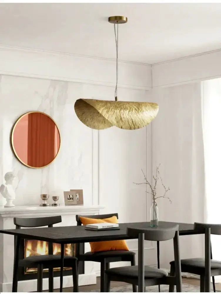 Modern gold lotus leaf pendant light by Decorbites over dining table in a chic dining room on Tampa Home & Garden Store