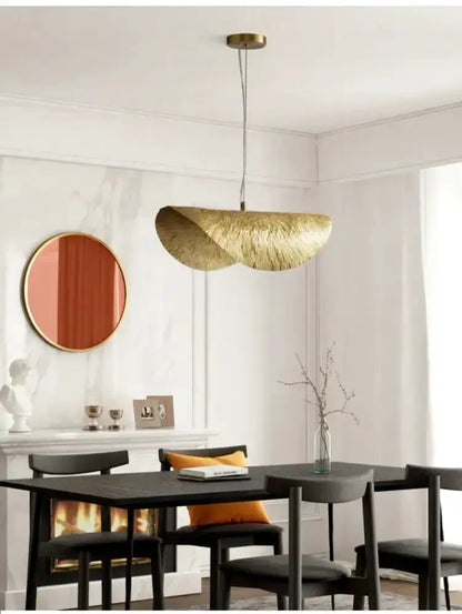 Modern gold lotus leaf pendant light by Decorbites over dining table in a chic dining room on Tampa Home & Garden Store