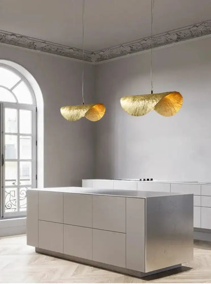 Decorbites modern gold lotus leaf pendant lights, two pendants over a sleek island on Tampa Home & Garden Store