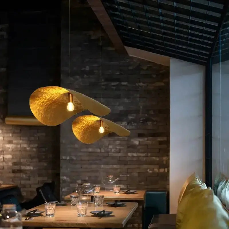 Modern gold lotus leaf pendant lights by Decorbites, twin hammered shades over dining table on Tampa Home & Garden Store