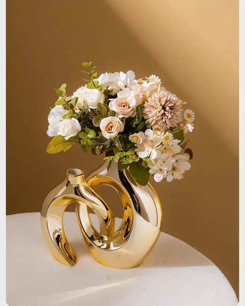 Golden ceramic flower vase by Decorbites with sculptural loop design, holds white blush bouquet on Tampa Home & Garden Store