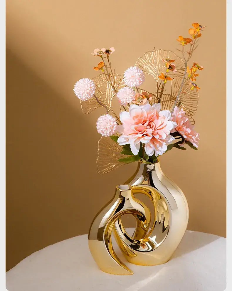 Golden Ceramic Flower Vase by Decorbites; sculptural gold loop design with pink bouquet on Tampa Home & Garden Store