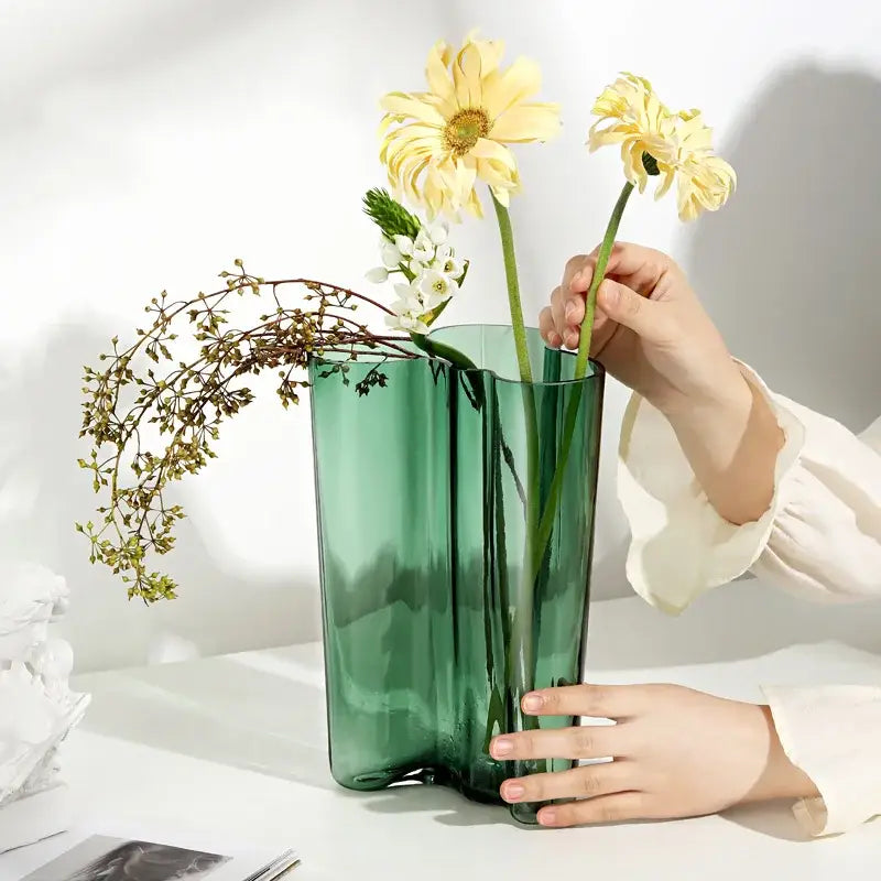 Emerald Glass Wavy Vase Decorbites, tall green vase with a wavy rim holding pale yellow flowers on Tampa Home & Garden Store