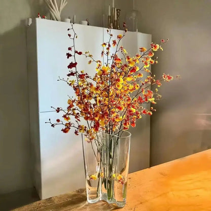 Emerald Glass Wavy Vase tall clear cylinder with orange-yellow blossoms on a wooden table on Tampa Home & Garden Store