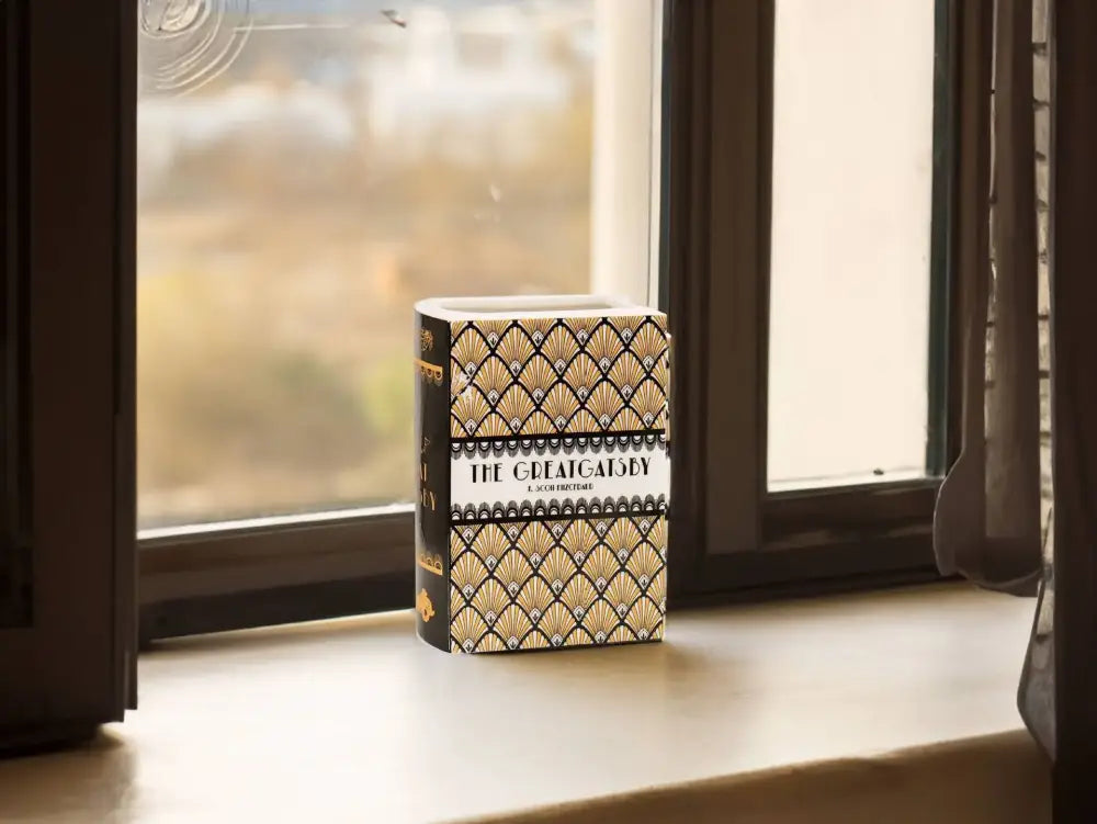 Navy ceramic book vase by Decorbites, book-shaped vase with gold fan pattern on a window sill on Tampa Home & Garden Store