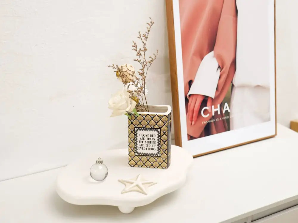 Navy ceramic book vase by Decorbites with dried stems on white shelf on Tampa Home & Garden Store