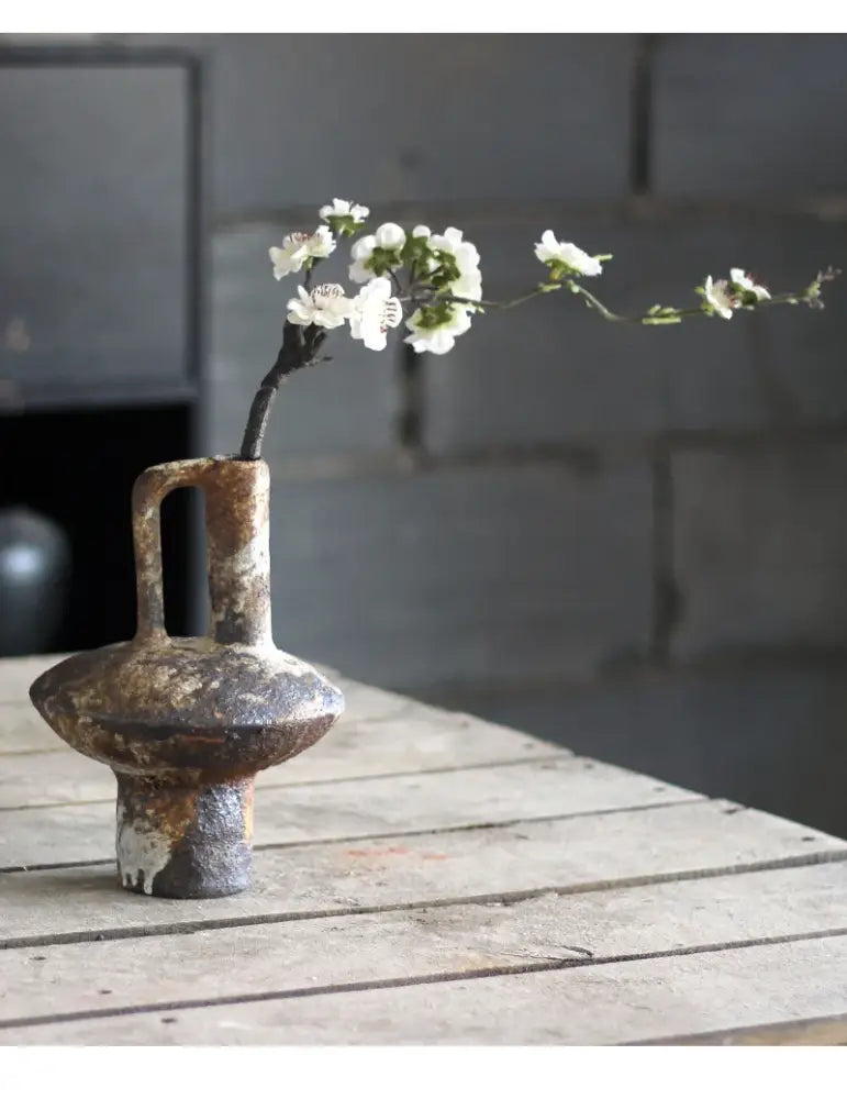 Brown gray ceramic vase by Decorbites with rustic patina, adorned with white blossoms on Tampa Home & Garden Store