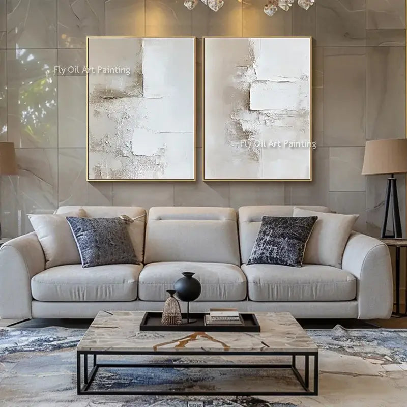 Two-panel beige and white abstract canvas oil paintings with gold frames above a neutral sofa on Tampa Home & Garden Store