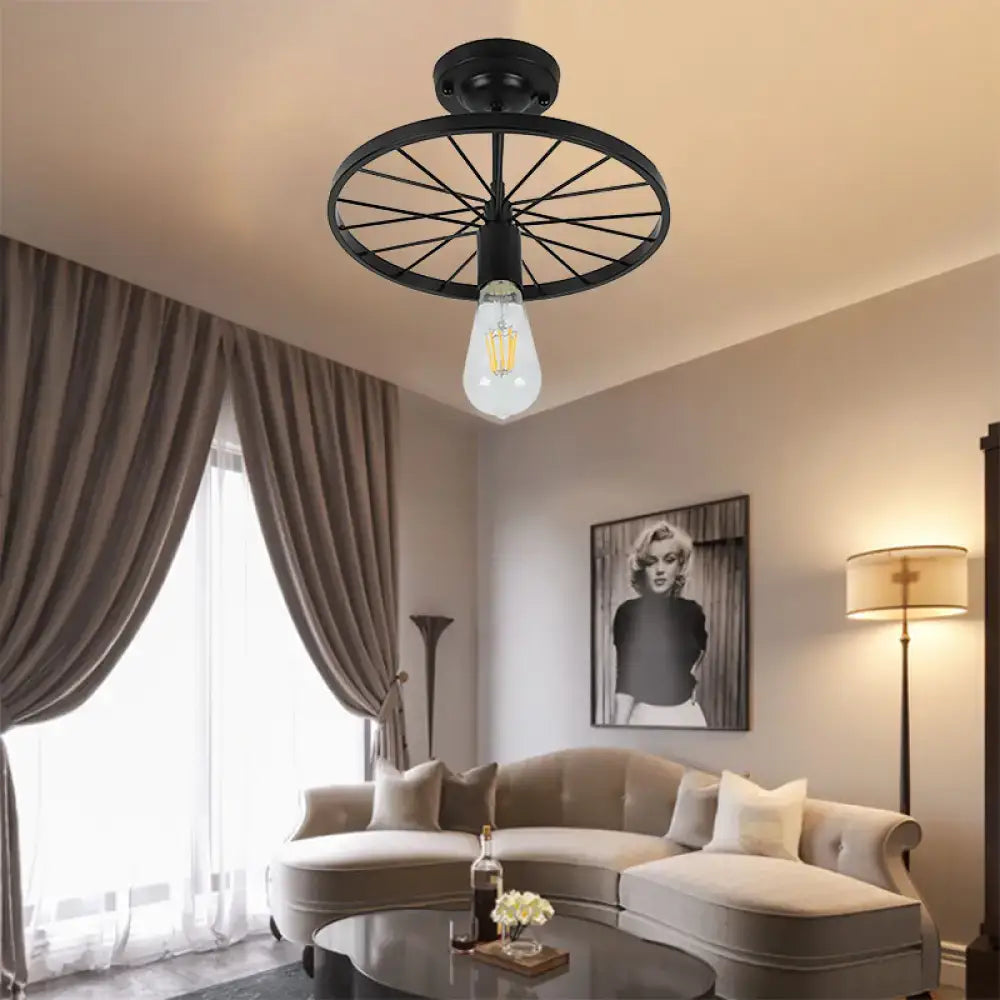 Black wheel ceiling light, wagon-wheel flush mount with exposed Edison bulb in living room on Tampa Home & Garden Store