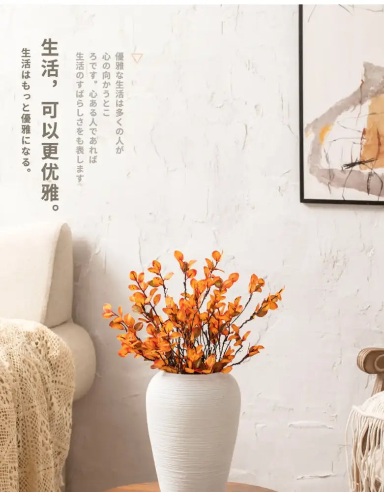 White ribbed ceramic vase by Decorbites with orange branches on a wooden table on Tampa Home & Garden Store