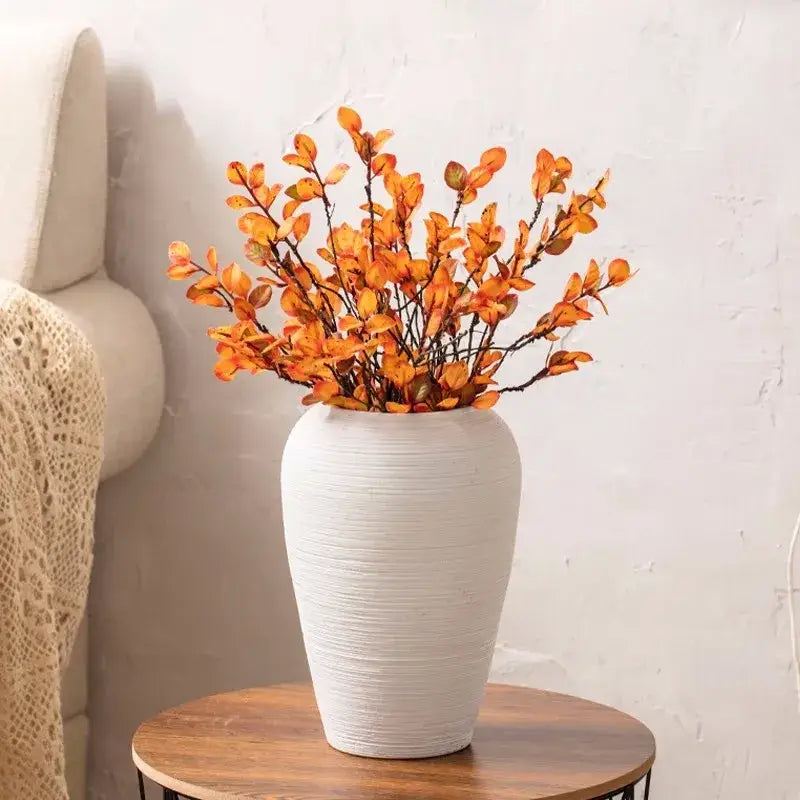 White ribbed ceramic vase by Decorbites with orange autumn branches on a wooden table on Tampa Home & Garden Store