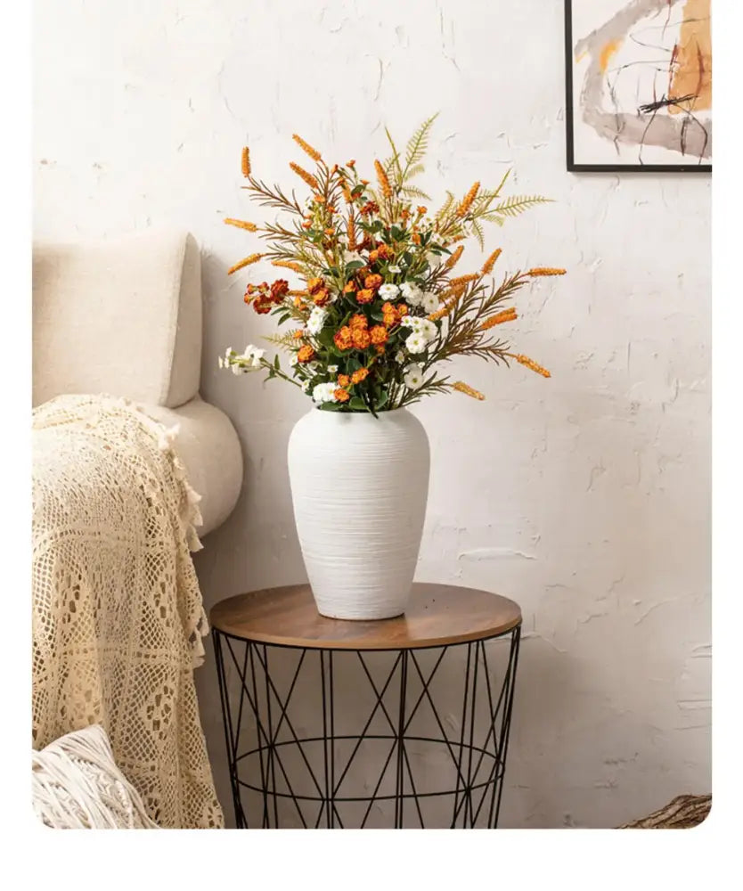 White ribbed ceramic vase by Decorbites with orange and white bouquet on a wood-top table on Tampa Home & Garden Store