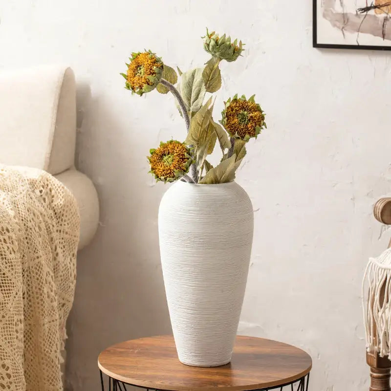 White ribbed ceramic vase by Decorbites with dried sunflowers on a round wooden table on Tampa Home & Garden Store
