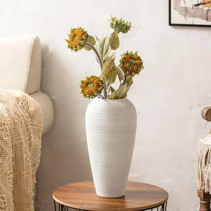 White ribbed ceramic vase by Decorbites with dried sunflowers on a round wooden table on Tampa Home & Garden Store