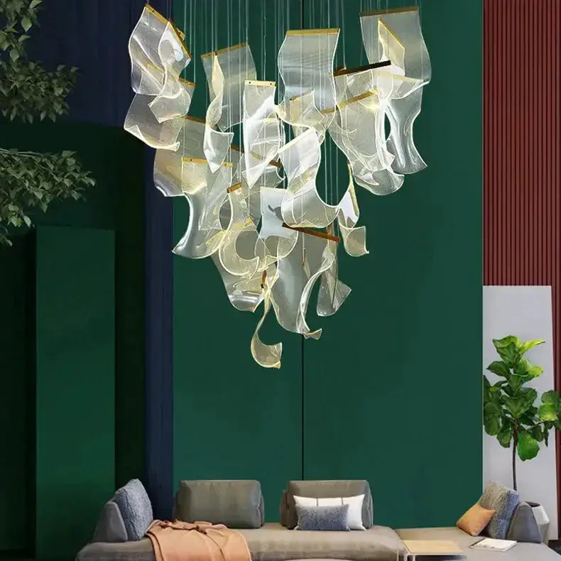 Modern gold sculptural LED chandelier by Decorbites with glass ribbons over a living room sofa on Tampa Home & Garden Store