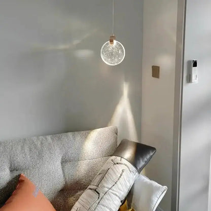 Decorbites modern gold LED crystal pendant light hanging above grey sofa in living room on Tampa Home & Garden Store