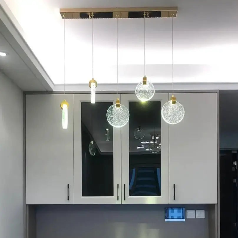 Modern gold LED crystal pendant light with five pendants hanging from a gold ceiling mount on Tampa Home & Garden Store