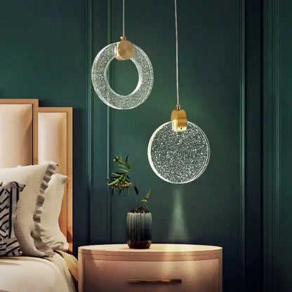 Gold LED crystal pendant lights, circular discs by Decorbites, pair hanging over nightstand on Tampa Home & Garden Store