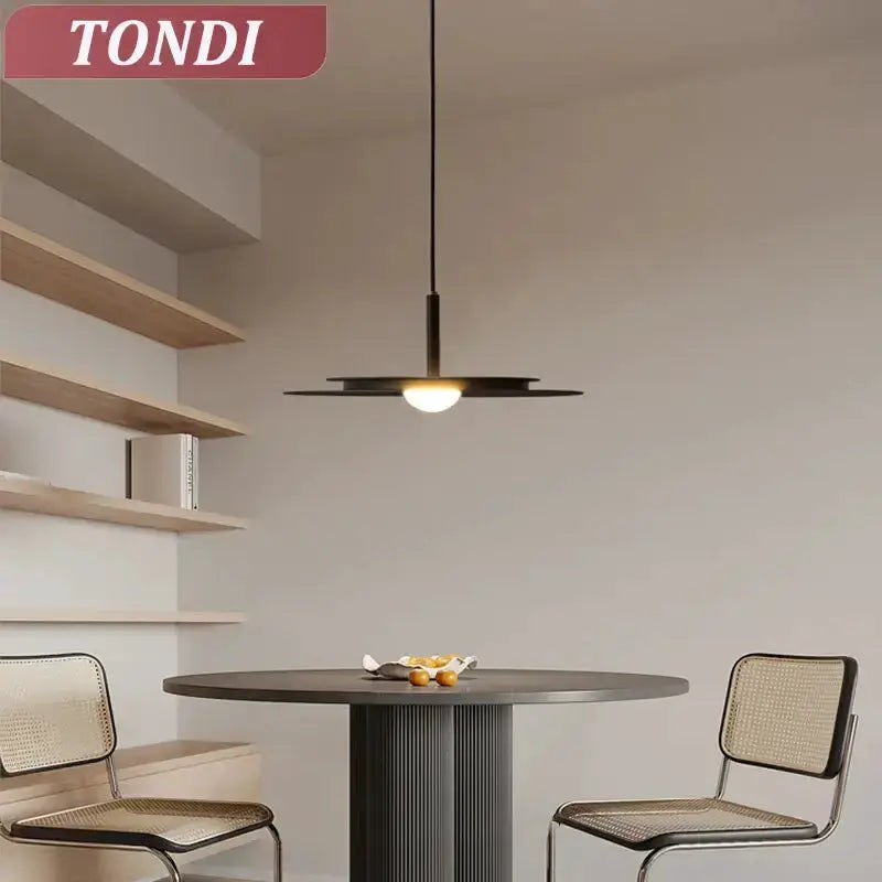 Minimalist black flying saucer pendant chandelier over a dining table, dark metal shade on Tampa Home & Garden Store
