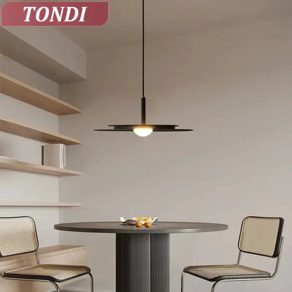 Minimalist black flying saucer pendant chandelier over a dining table, dark metal shade on Tampa Home & Garden Store