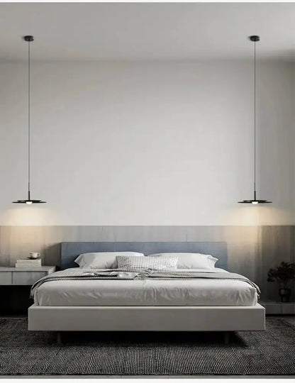 Minimalist black flying saucer pendant chandelier, 2 pendants on slender cords over a bed on Tampa Home & Garden Store