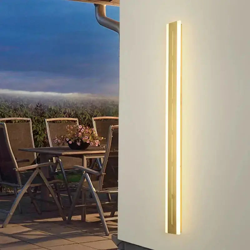 Vertical brass LED outdoor wall light, slim minimalist garden sconce with warm glow on Tampa Home & Garden Store