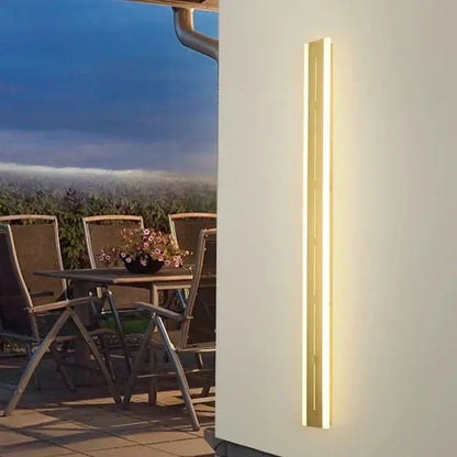 Vertical brass LED outdoor wall light, slim minimalist garden sconce with warm glow on Tampa Home & Garden Store